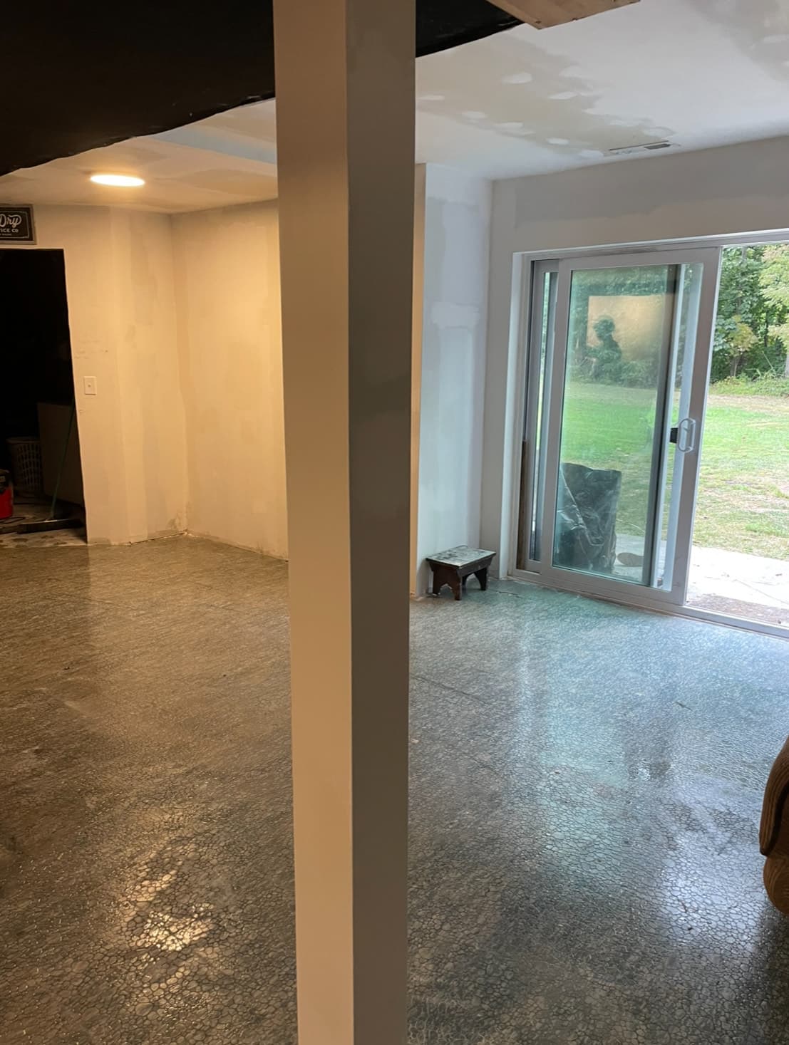 Finished basement room with sliding glass door and smooth painted walls