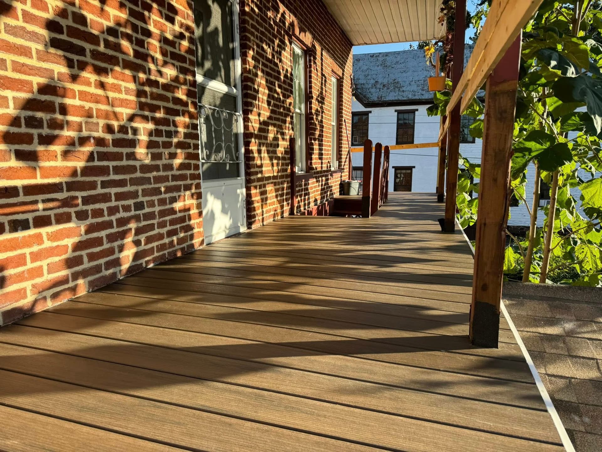 Composite deck boards on a covered brick porch in evening light