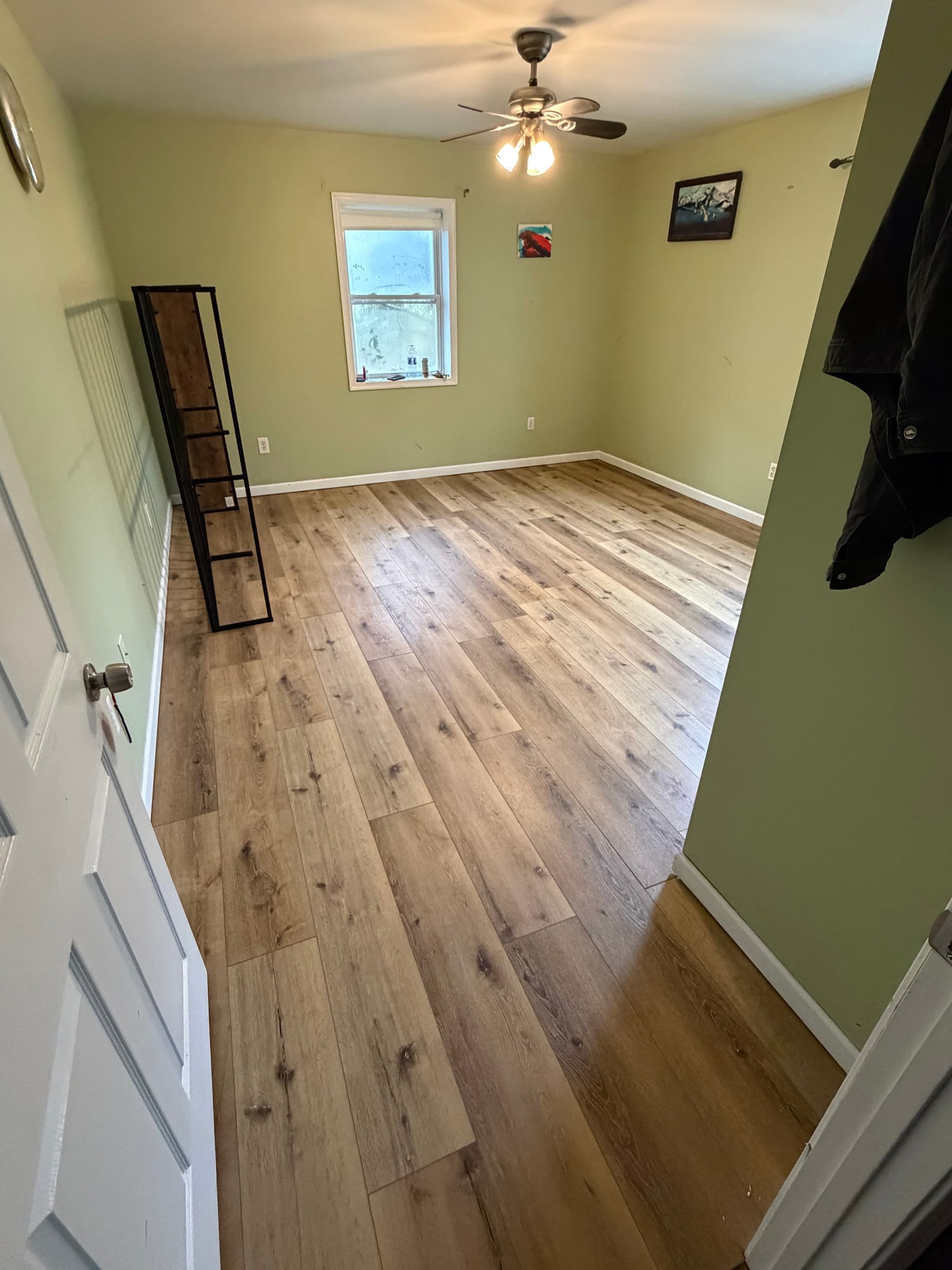 Finished bedroom with wood-look vinyl plank flooring and fresh trim